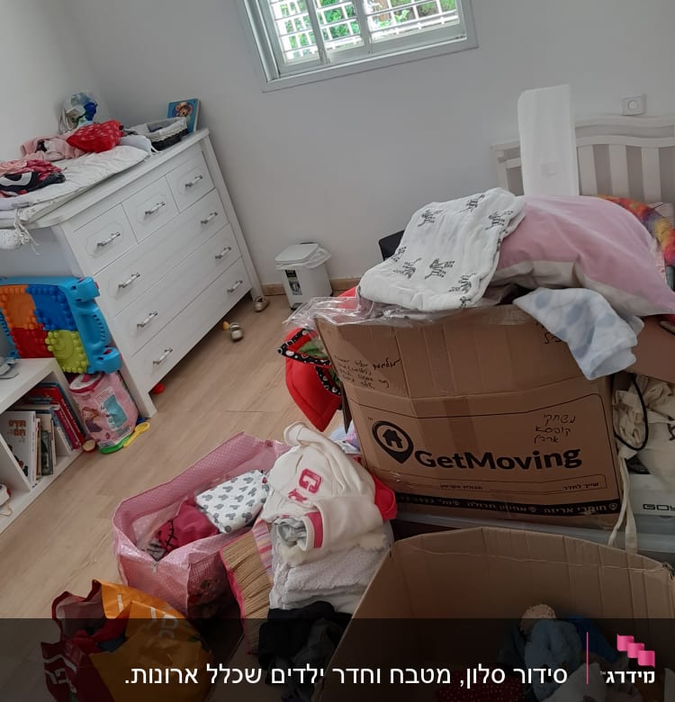 בגדים וצעצועים בארגזים בחדר ילדים